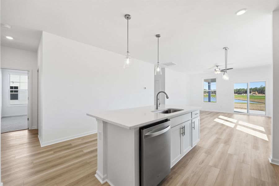 Kitchen with recessed lighting, dishwasher, decorative light fixtures, white cabinetry, and a kitchen island with sink Kitchen with recessed lighting, dishwasher, decorative light fixtures, white cabinetry, and a kitchen island with sink