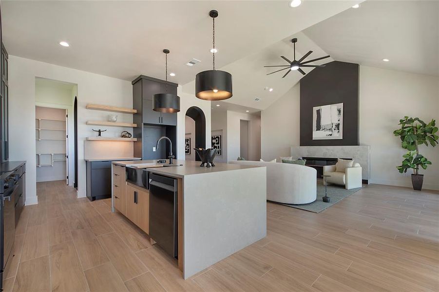 Kitchen with an island with sink, wood finish floors, arched walkways, ceiling fan, and recessed lighting Kitchen with an island with sink, wood finish floors, arched walkways, ceiling fan, and recessed lighting