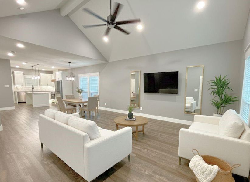 Living room with recessed lighting, ceiling fan, high vaulted ceiling, beamed ceiling, and light wood-type flooring Living room with recessed lighting, ceiling fan, high vaulted ceiling, beamed ceiling, and light wood-type flooring