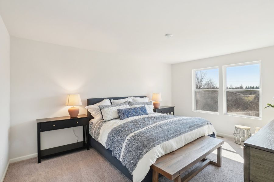 A bedroom with a bed and a bench. A bedroom with a bed and a bench.