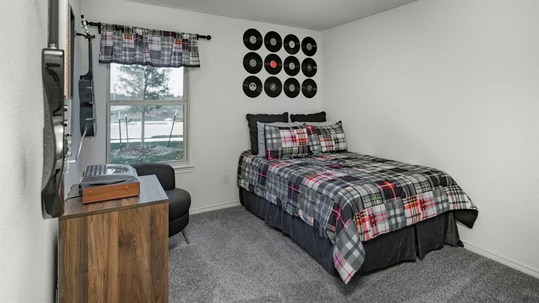 Bedroom with light colored carpet and baseboards