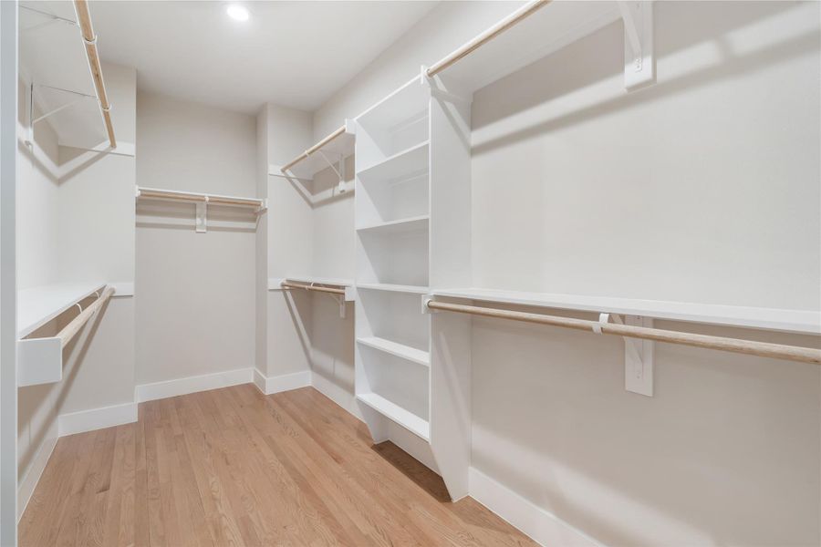 The spacious primary walk-in closet offers abundant hanging space and built-in shelving. The spacious primary walk-in closet offers abundant hanging space and built-in shelving.