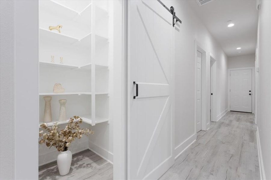 Hallway featuring a barn door and light wood-type flooring