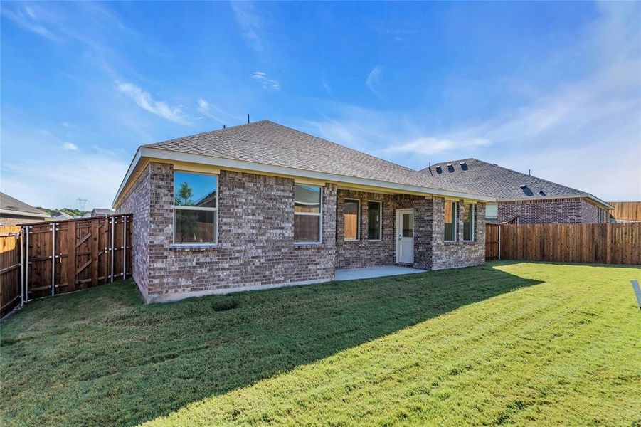 Rear view of house featuring a patio and a yard