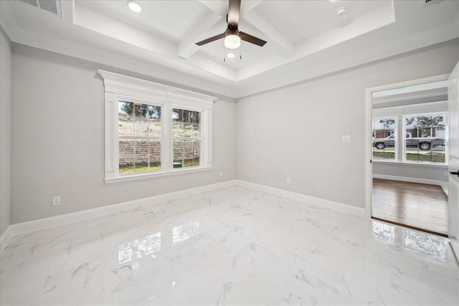 Spare room with ceiling fan, beam ceiling, and coffered ceiling