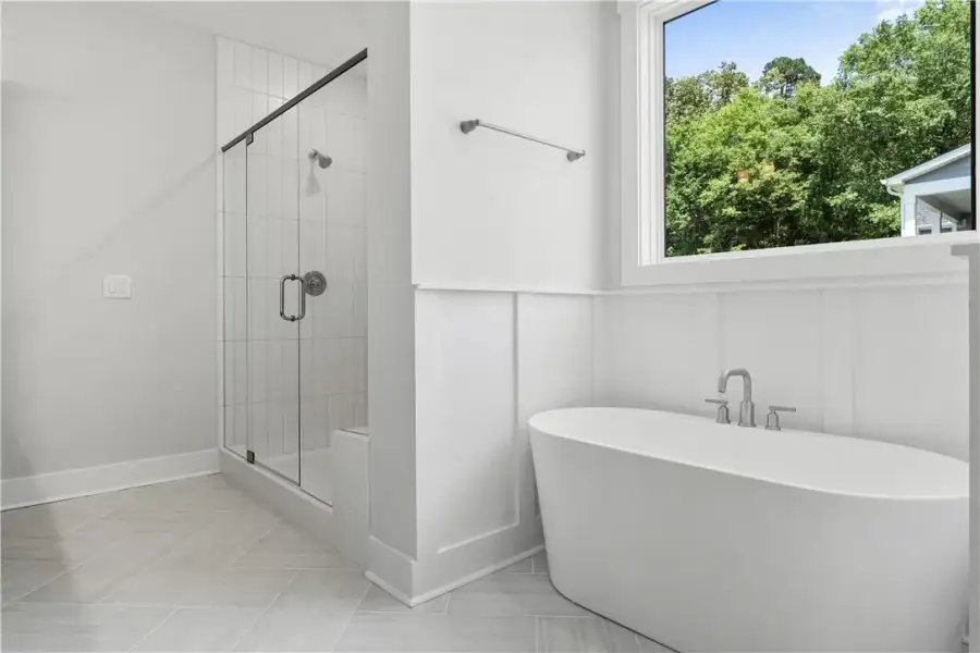 A freestanding soaking tub and glass-enclosed show A freestanding soaking tub and glass-enclosed show