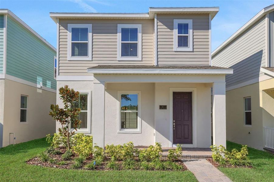 Front exterior of a new home in Serenade at Ovation, Winter Garden, FL, highlighting curb appeal (Image 1). Front exterior of a new home in Serenade at Ovation, Winter Garden, FL, highlighting curb appeal (Image 1).