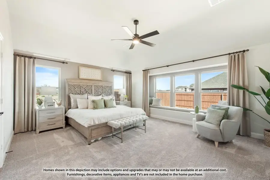 Spacious master bedroom with vaulted ceiling, ceiling fan, window seat, and neutral carpet flooring