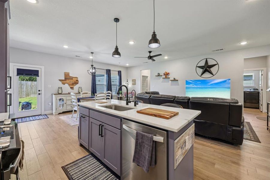 Kitchen featuring stainless steel appliances, open floor plan, light wood-type flooring, recessed lighting, and light stone counters Kitchen featuring stainless steel appliances, open floor plan, light wood-type flooring, recessed lighting, and light stone counters