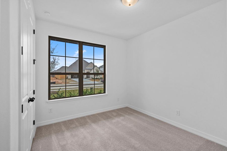 A secondary bedroom designed for comfort, featuring warm finishes and an easygoing feel.