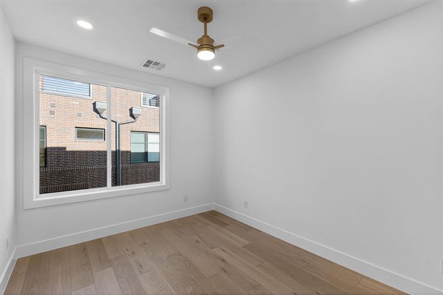 Bedroom with light wood-type flooring, a ceiling fan, and recessed lighting