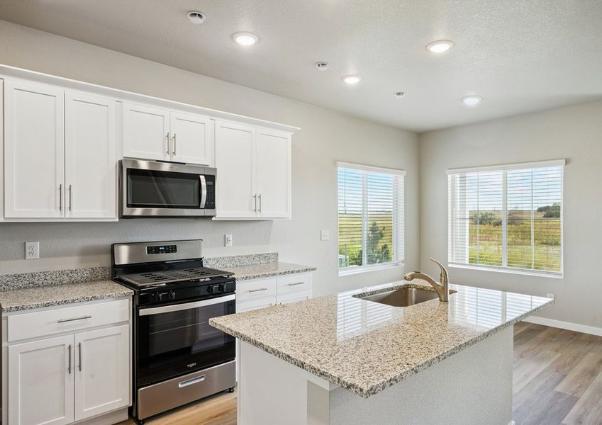 The kitchen has stainless steel appliances and plank flooring.