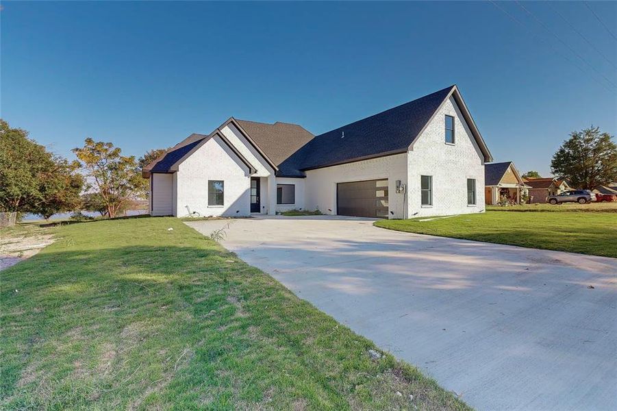 View of side of property with a garage and a yard