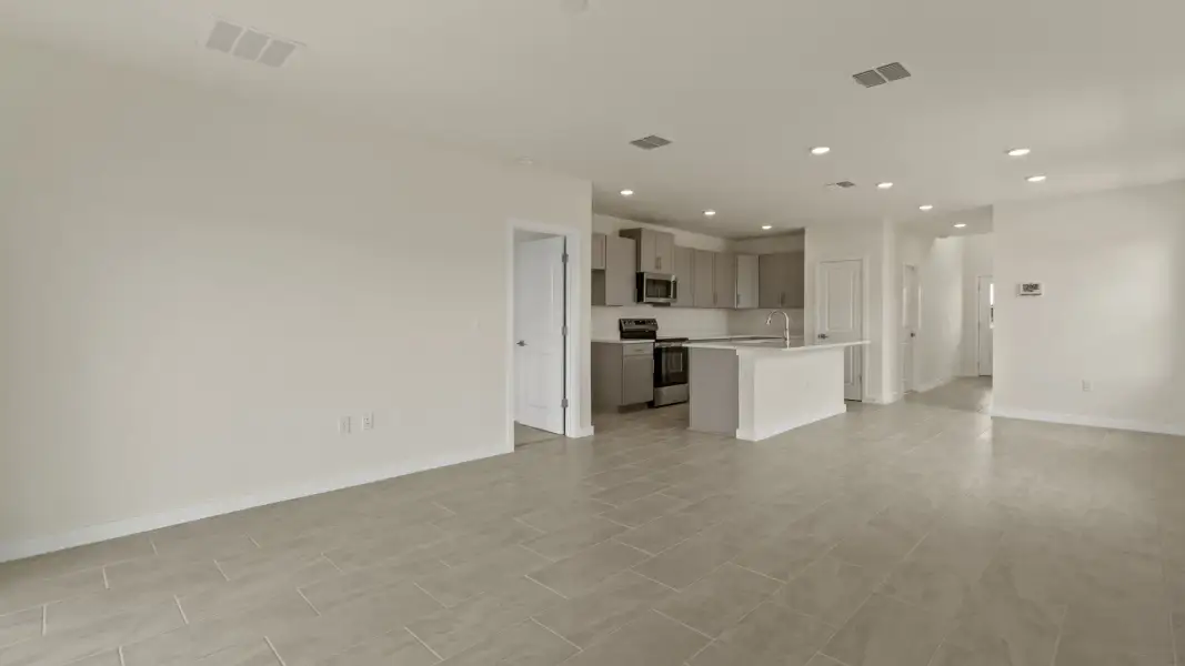 The Naples Living Area and Kitchen with large Island Quick Move-In Home at Willowbrook North by DRB Homes in Winter Haven, FL