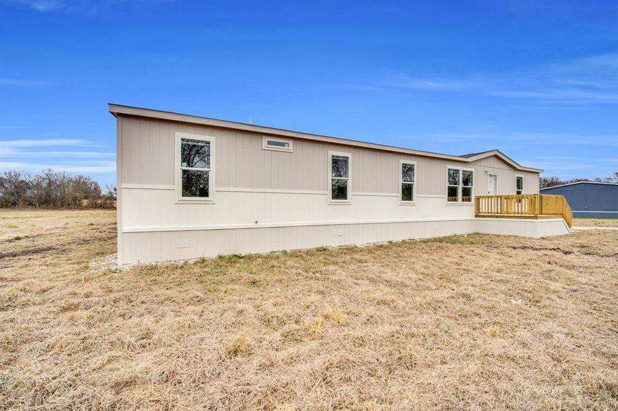 View of side of property featuring a yard and a deck