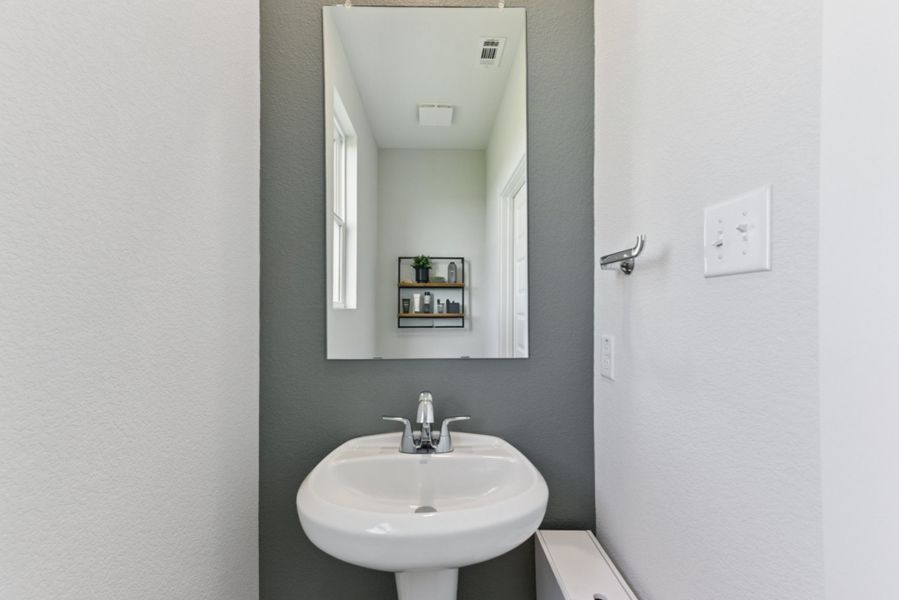 A bathroom with a mirror and sink. A bathroom with a mirror and sink.