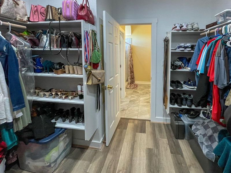 Walk in closet with light wood-type flooring