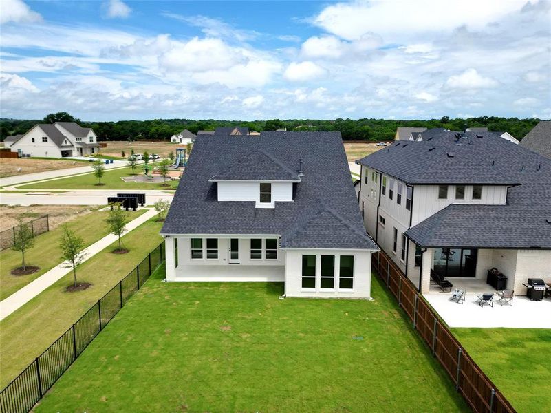 Back of house with a shingled roof, a patio area, a fenced backyard, and a residential view Back of house with a shingled roof, a patio area, a fenced backyard, and a residential view