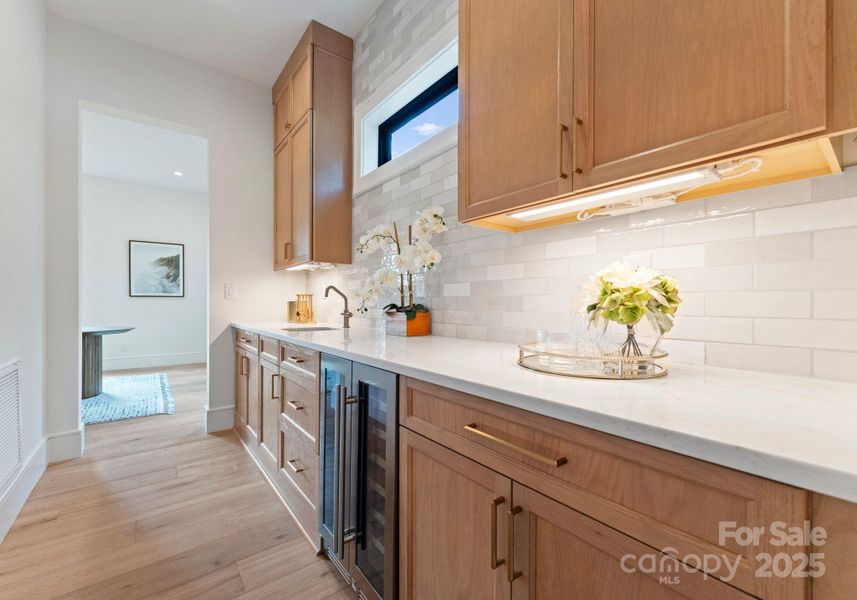 Butlers pantry complete with sink, dual zone wine fridge, and floor to ceiling Marsh cabinetry. Connects the kitchen and dining room and accesses the formal walk-in pantry. Butlers pantry complete with sink, dual zone wine fridge, and floor to ceiling Marsh cabinetry. Connects the kitchen and dining room and accesses the formal walk-in pantry.