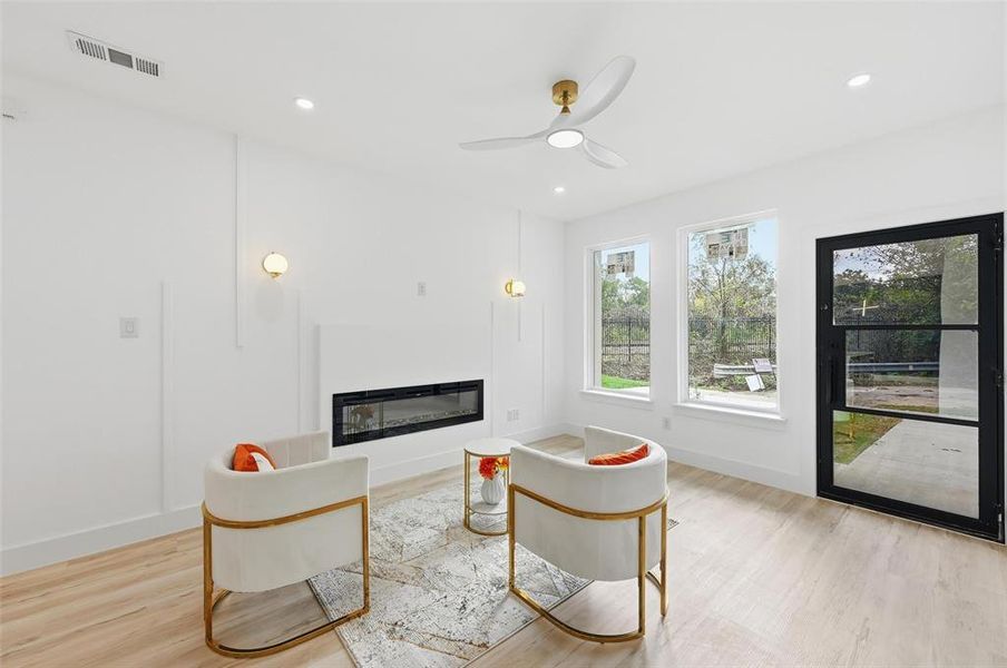 Living room a glass covered fireplace, ceiling fan, and recessed lighting Living room a glass covered fireplace, ceiling fan, and recessed lighting