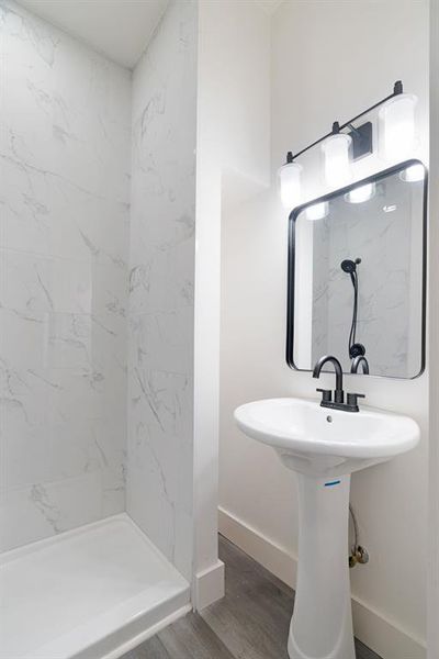 Bathroom featuring wood finished floors and a walk in shower Bathroom featuring wood finished floors and a walk in shower