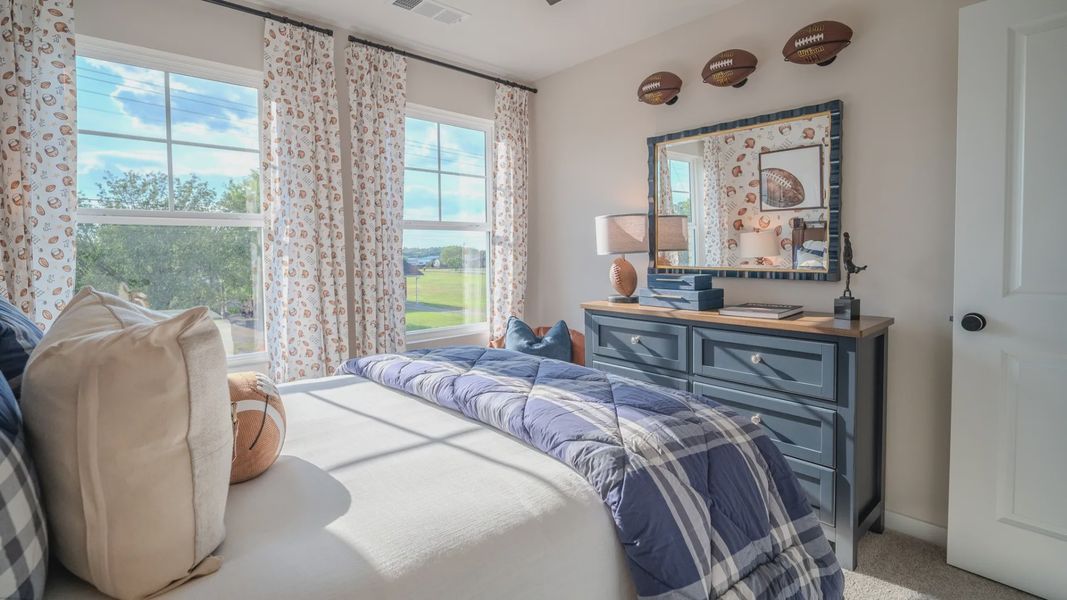 Secondary bedroom with carpet and windows