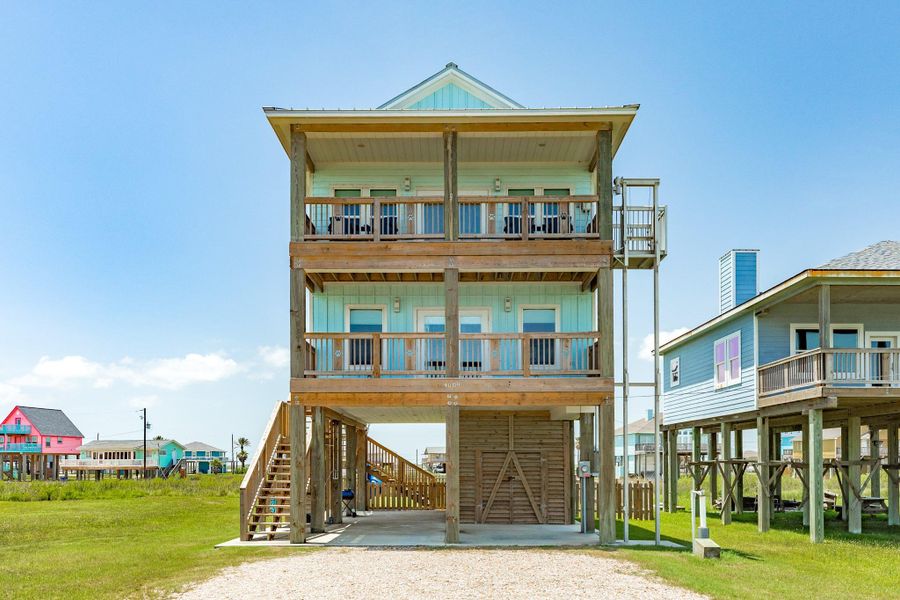 Charming coastal exterior offers multiple covered outdoor living spaces, an elevated design, and low-maintenance finishes ideal for a beach getaway.