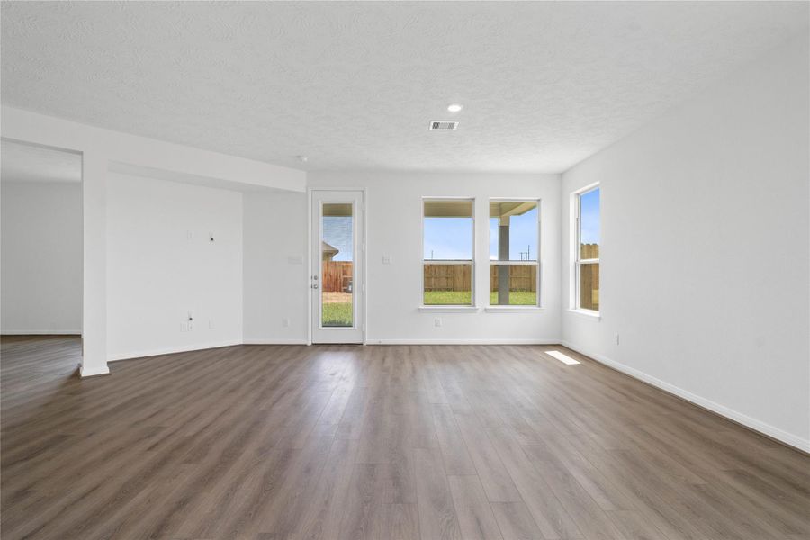 This light and bright spacious Great Room is the perfect layout for entertaining or just relaxing. Whether it's simply a night in or entertaining family and friends, this home has ample open space for everyone to enjoy! Featuring Layton Lake vinyl plank flooring in Ashen Brown, large windows, high ceilings, recessed lighting, and wonderful access to the kitchen and dining area.