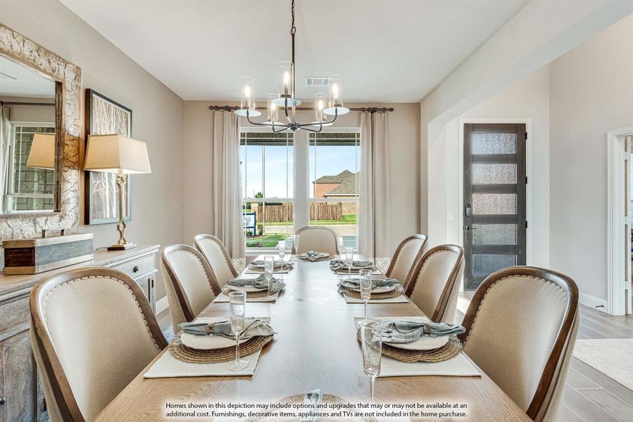 Formal dining room with long wood table, eight upholstered chairs, chandelier, and large window with backyard view.