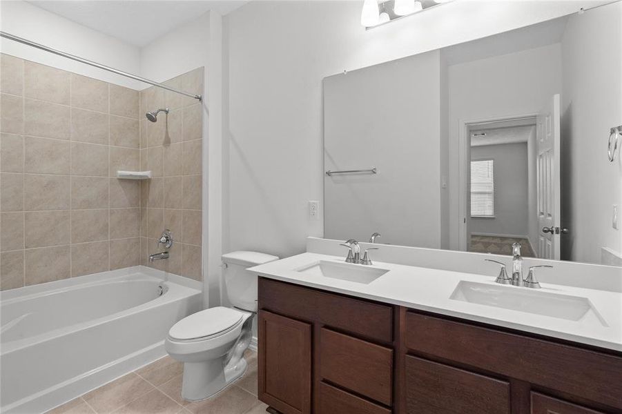 This primary bathroom is definitely move-in ready! Featuring an oversized tub and shower combo with tile surround, stained cabinets with light countertops, high ceilings, custom paint, sleek and modern finishes.