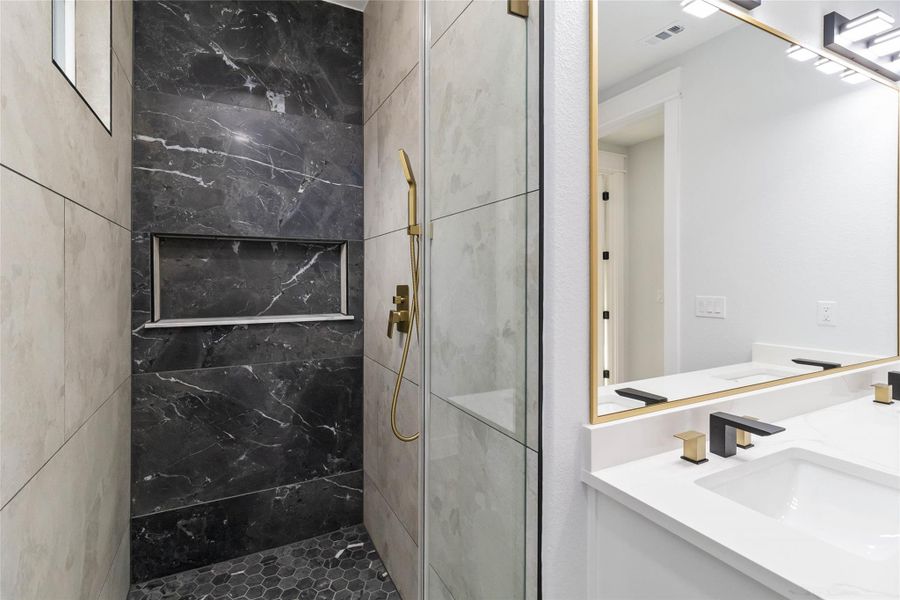 Full bathroom with a marble finish shower and vanity