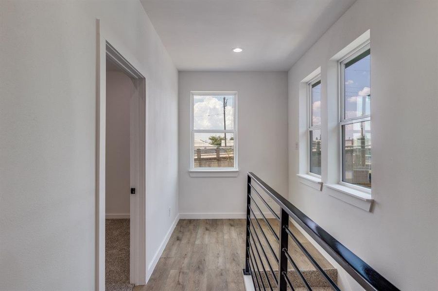 Corridor featuring light wood-type flooring and recessed lighting
