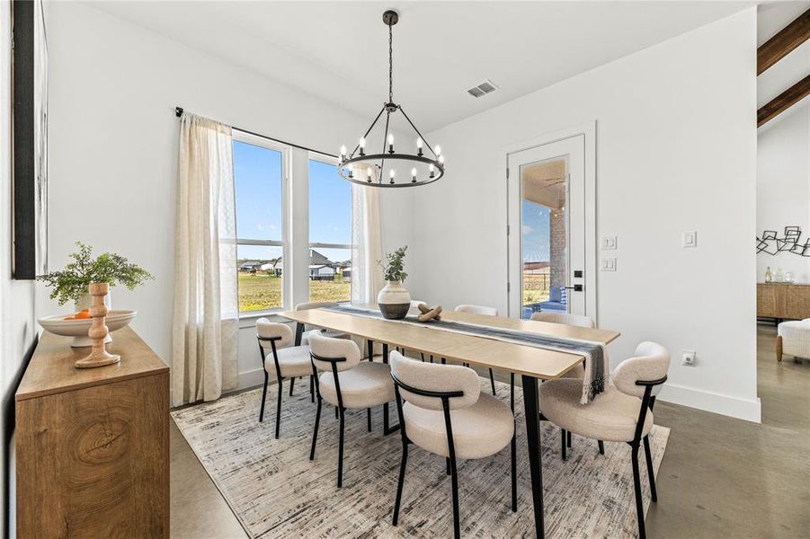 Dining area featuring a chandelier and concrete floors Dining area featuring a chandelier and concrete floors