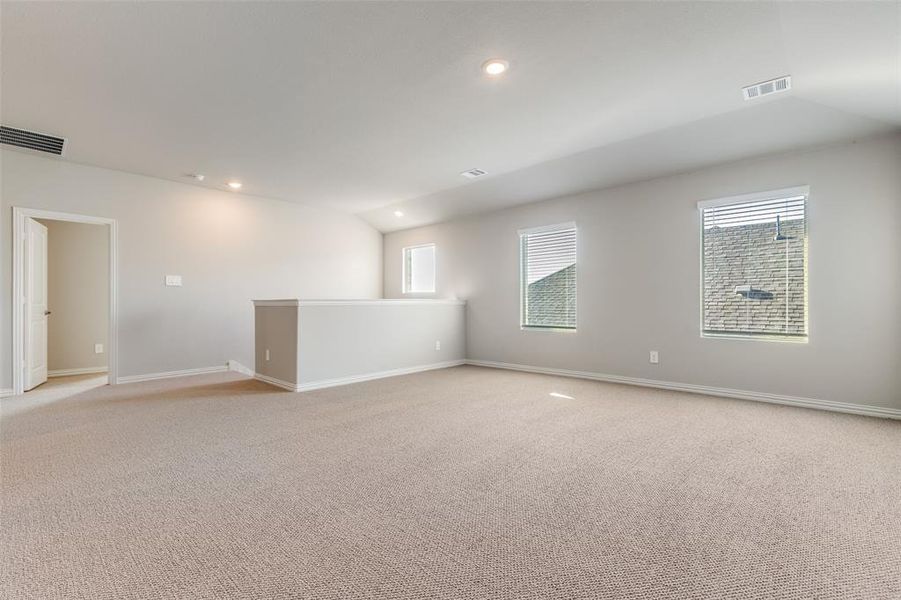 Unfurnished room with light colored carpet, recessed lighting, and lofted ceiling Unfurnished room with light colored carpet, recessed lighting, and lofted ceiling