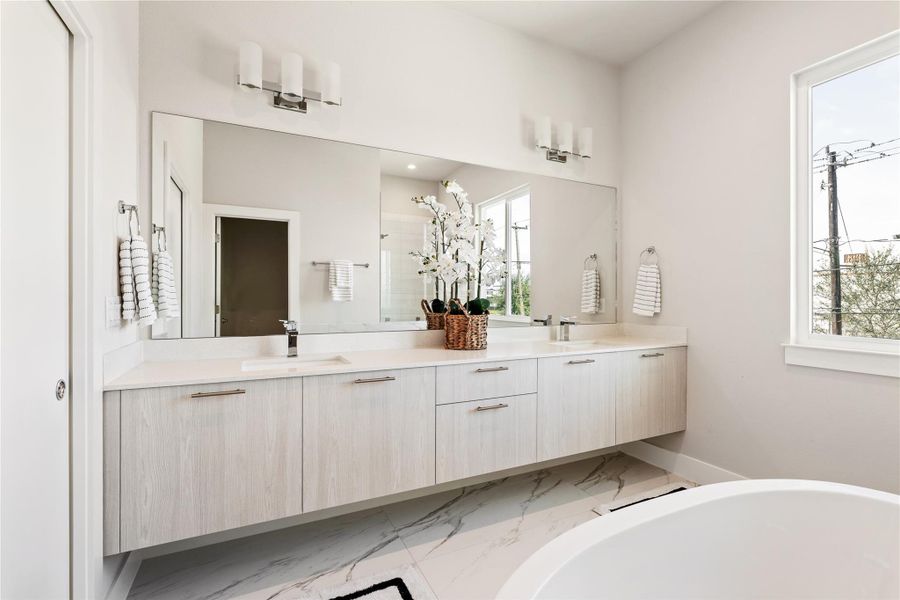 A private ensuite that feels intentional, not oversized for the sake of it. Dual floating vanities with integrated storage anchor the space, paired with an expansive wall-to-wall mirror that amplifies light and scale.