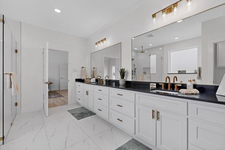 Bathroom featuring a stall shower, double vanity, recessed lighting, a walk in closet, and light marble finish floors
