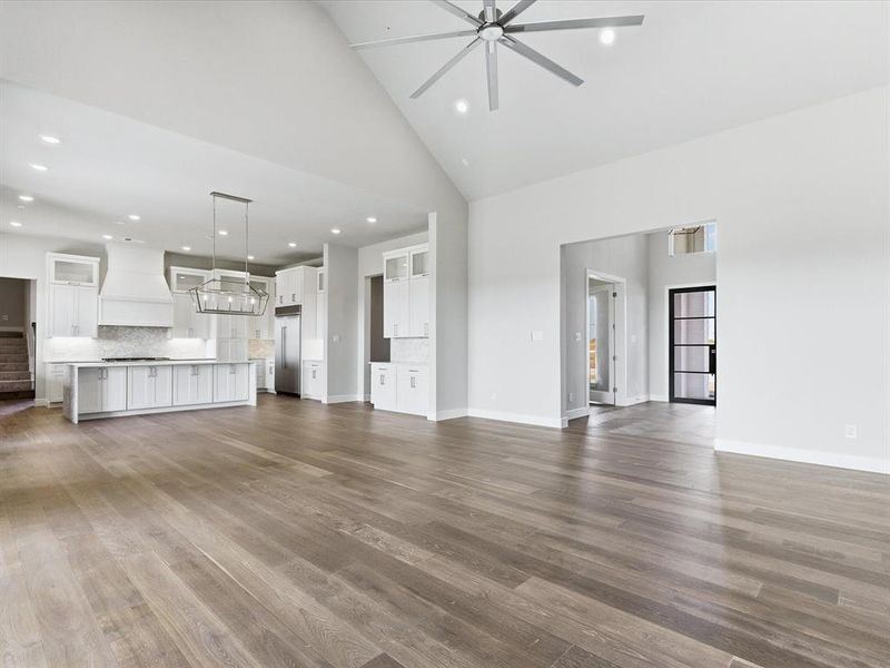 Unfurnished living room featuring high vaulted ceiling, dark wood-style flooring, recessed lighting, and ceiling fan