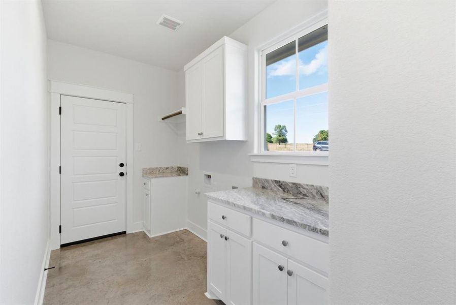 Laundry room featuring concrete flooring, cabinet space, and hookup for a washing machine