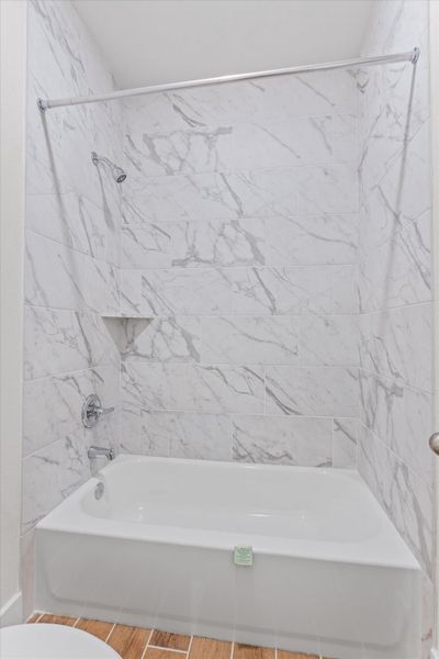 Experience daily refreshment in this elegant bathroom with a shower-over-tub design and sleek marble-patterned tile. Experience daily refreshment in this elegant bathroom with a shower-over-tub design and sleek marble-patterned tile.