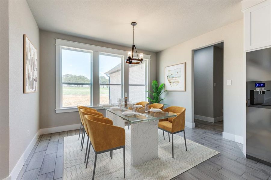 Dining room featuring light hardwood / wood-style flooring and an inviting chandelier
Virtual Staging