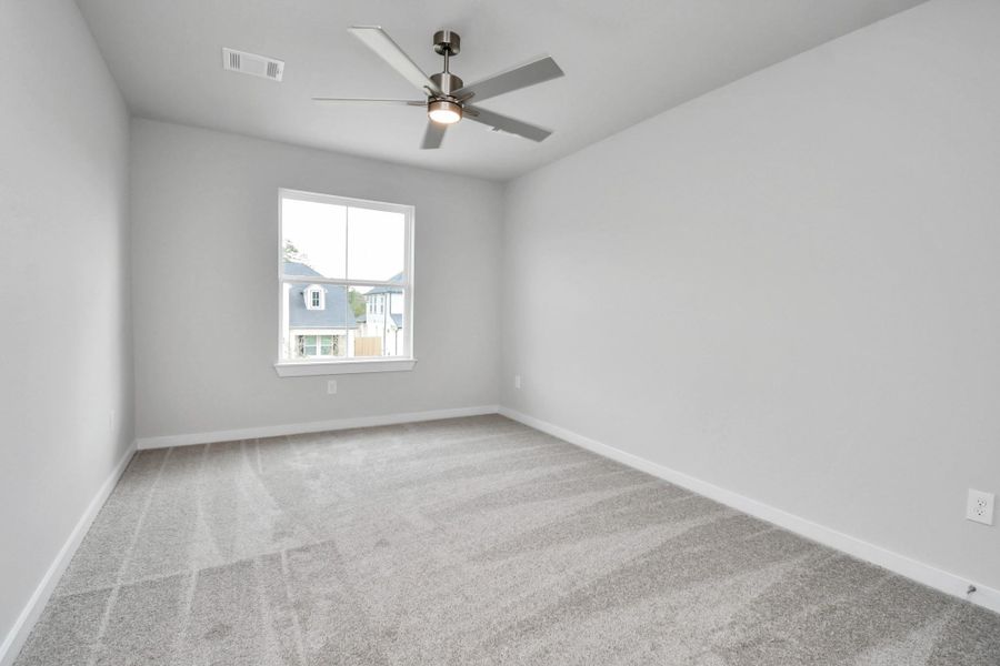 Secondary bedroom features plush carpeting, large windows that let in plenty of natural light, bright paint, and spacious closets. Sample photo of completed home with similar floor plan. Actual colors and selections may vary. Secondary bedroom features plush carpeting, large windows that let in plenty of natural light, bright paint, and spacious closets. Sample photo of completed home with similar floor plan. Actual colors and selections may vary.