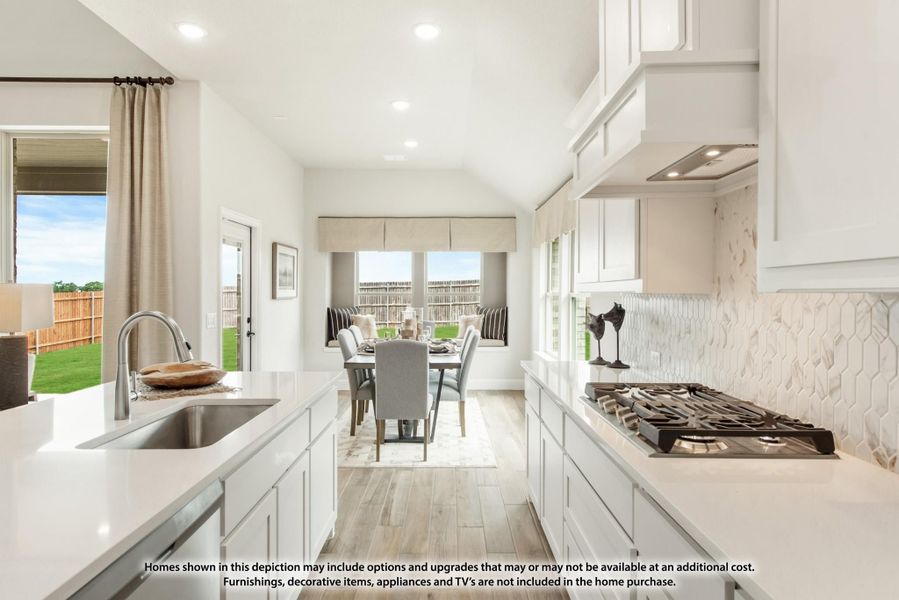 Kitchen with white cabinets, quartz countertops, gas cooktop, and tile backsplash open to dining area with backyard view.