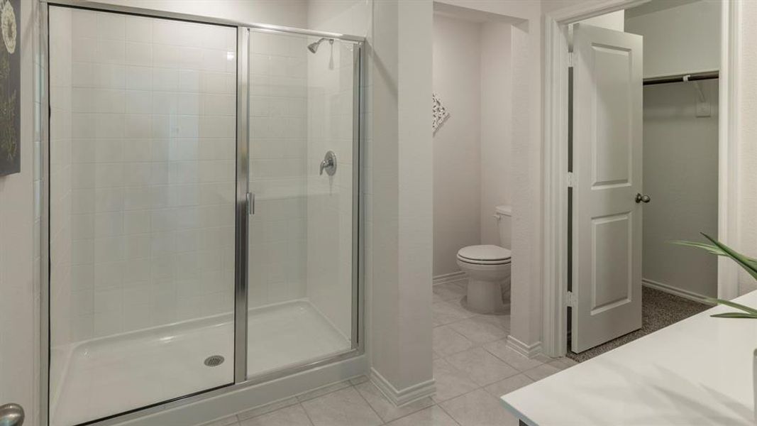 Bathroom with vanity, a stall shower, light tile patterned floors, and a spacious closet