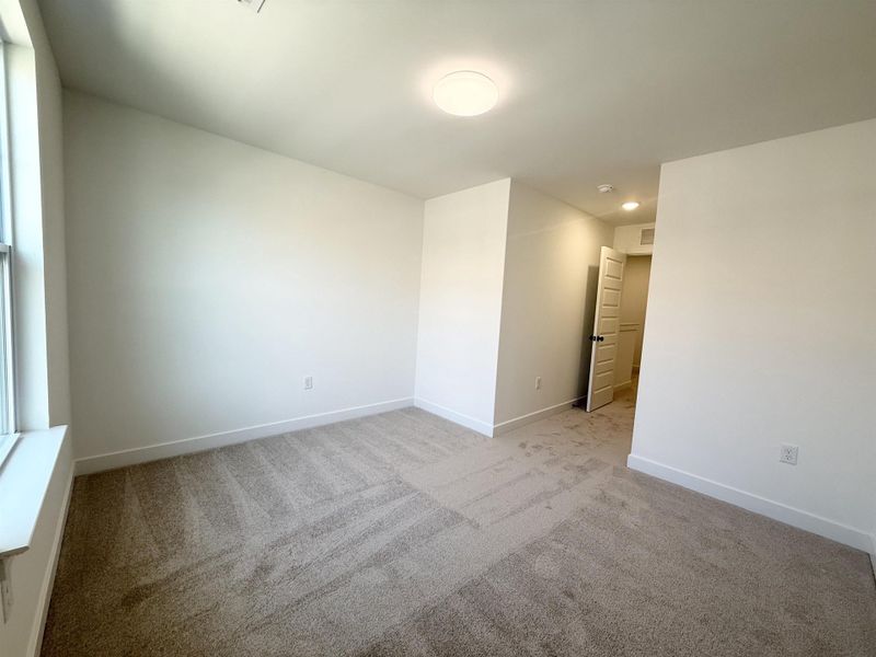 Empty room featuring light colored carpet and baseboards