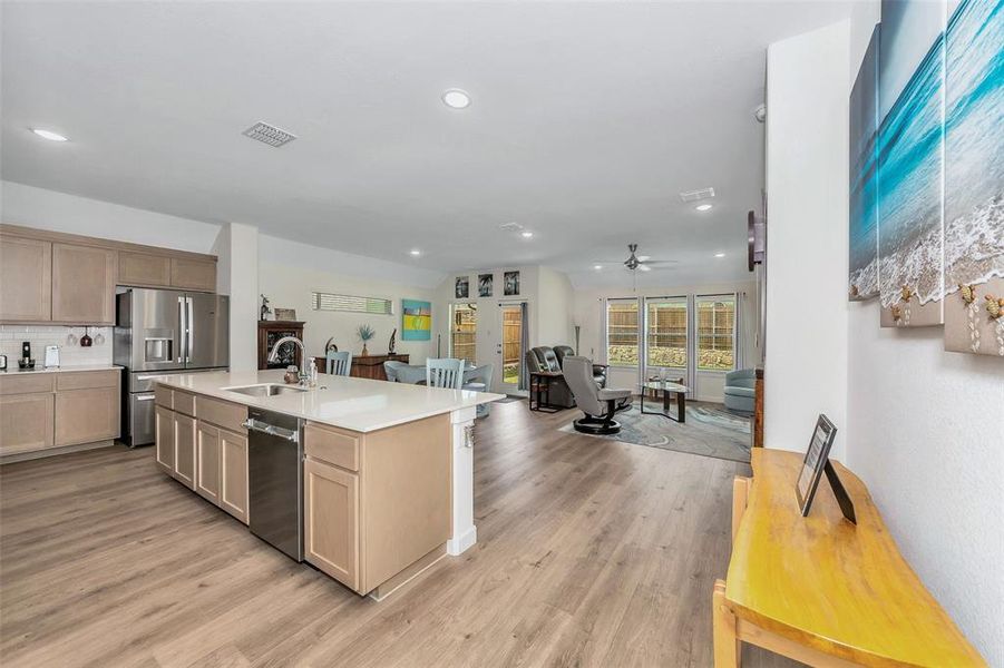 Kitchen featuring ceiling fan, an island with sink, stainless steel appliances, sink, and light wood-type flooring