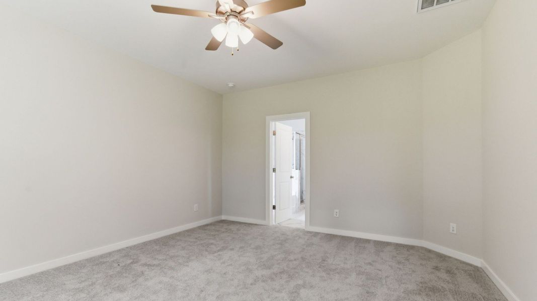 Primary Suite with carpet and ceiling fan