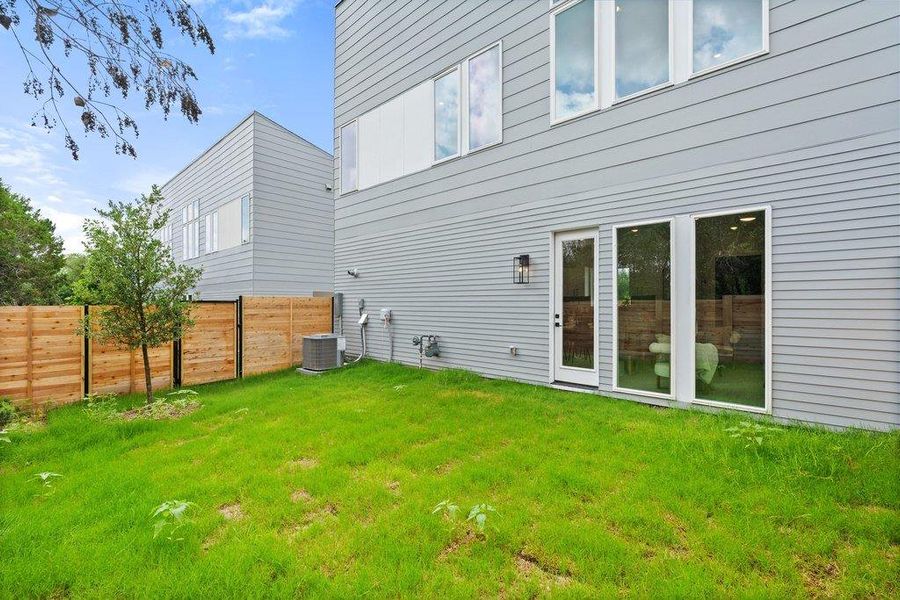 The property features a private yard with a wooden fence and a grassy lawn