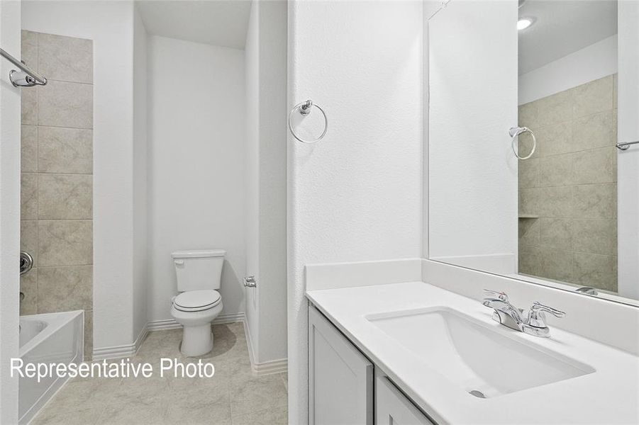 Bathroom featuring a vanity with an integrated sink, polished chrome faucet, and expansive mirror