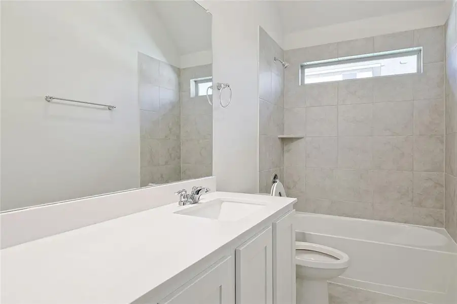 Full bathroom featuring vanity, bathtub / shower combination, and vaulted ceiling