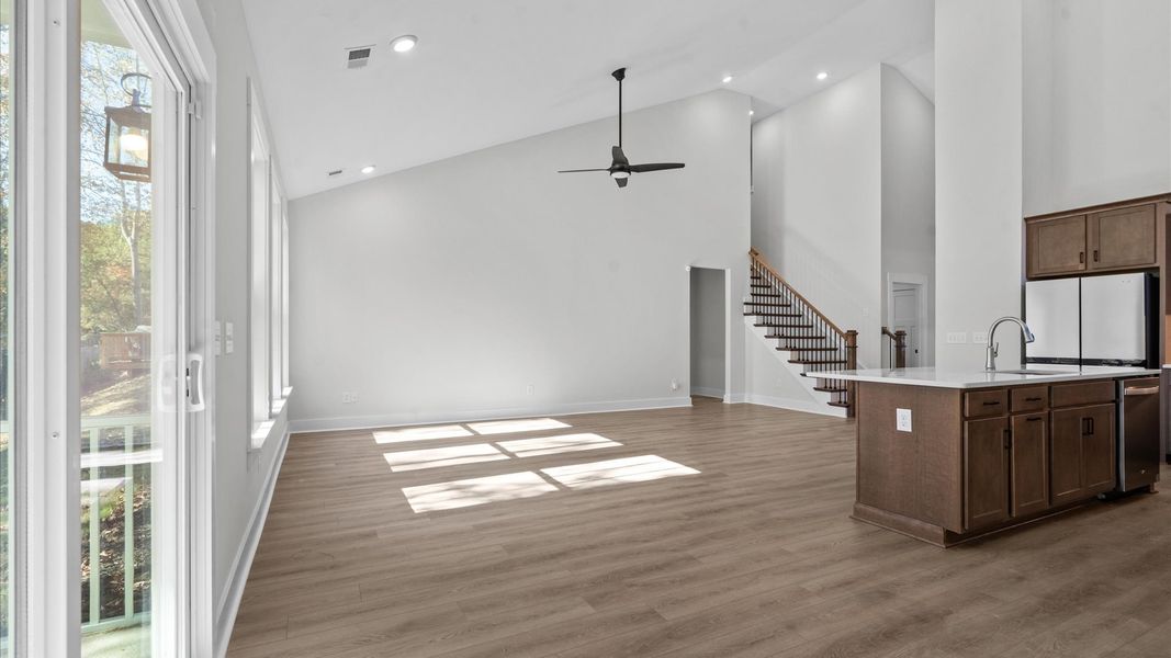 First-class living space featuring expansive ceilings, elegant design, and open sightlines to the kitchen First-class living space featuring expansive ceilings, elegant design, and open sightlines to the kitchen